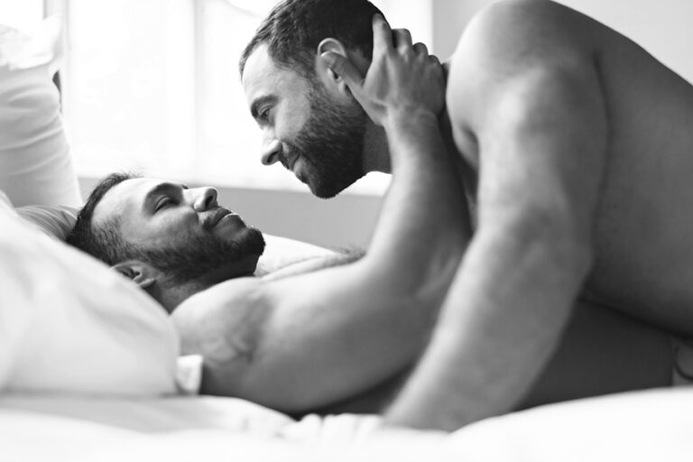 Handsome gay men couple on bed together